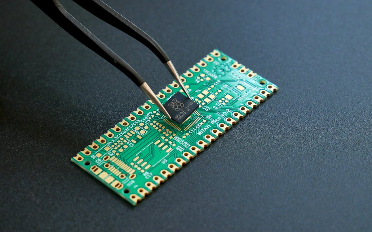 Tweezers placing a chip on a circuit board